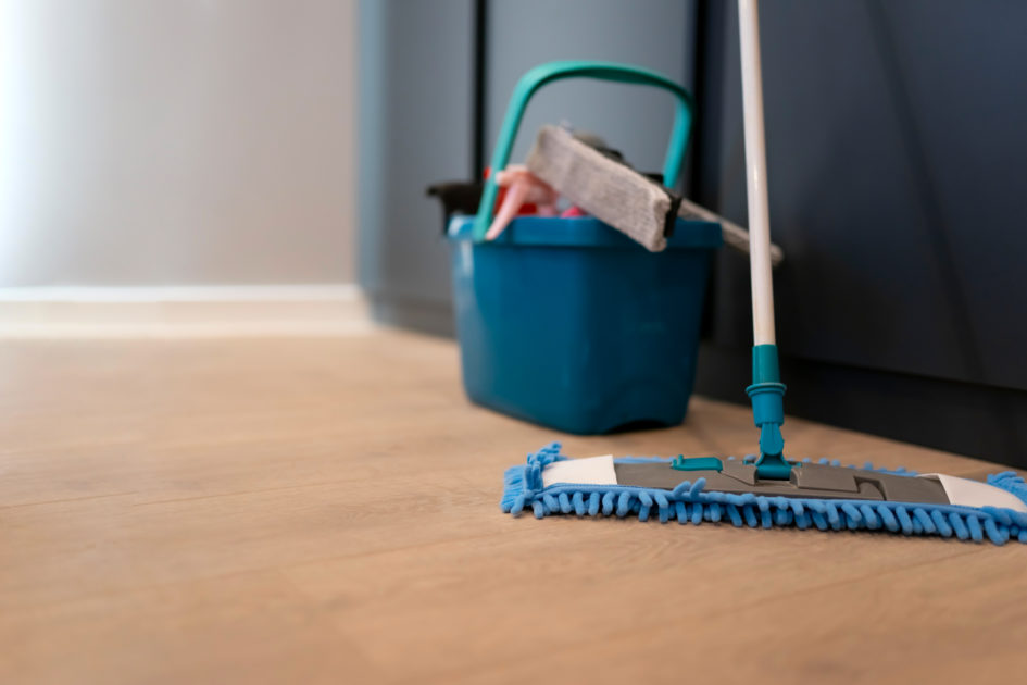 Blue microfiber mop with cleaning bucket on tile floor for fast cleaning routines