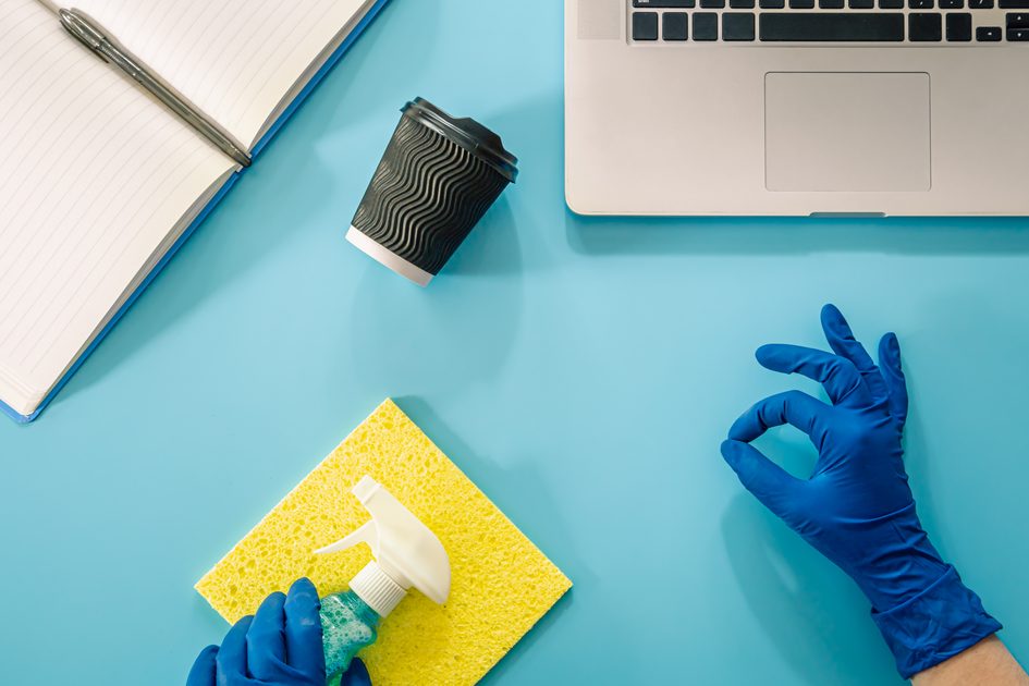 cleaning supplies on blue desk with laptop utc